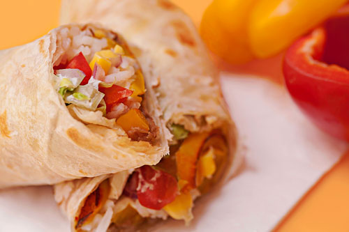 Vegetarian Burrito next to some bell peppers